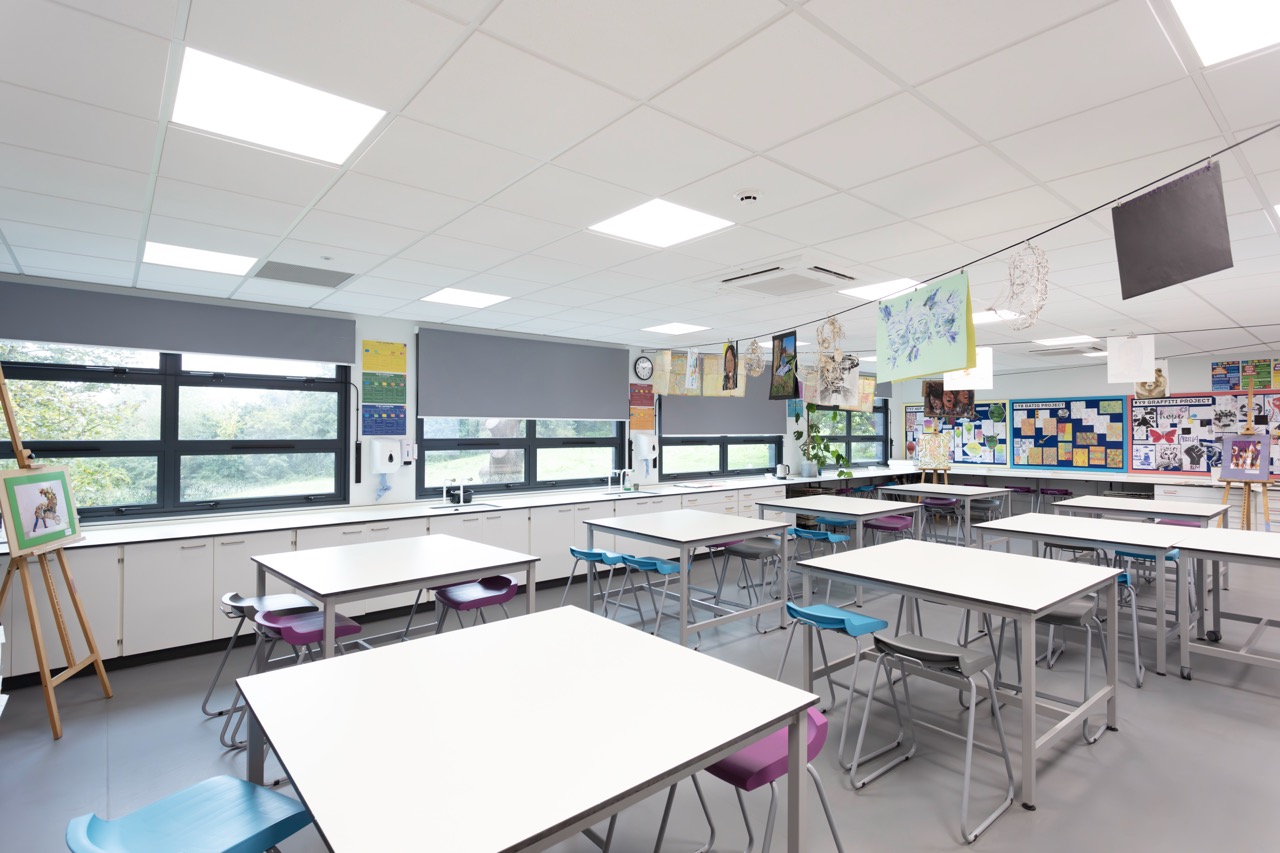 Bright and colourful art classroom with vibrant displays, smooth wall finishes and well-coordinated furnishings in an educational setting.